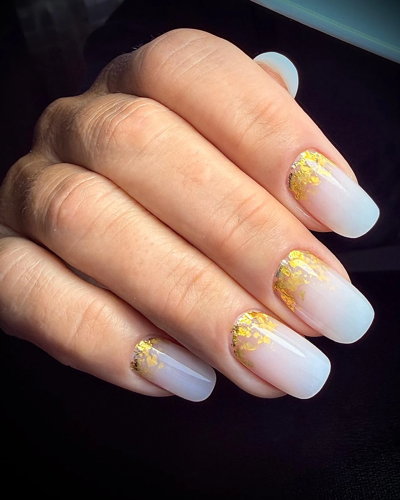 Manicure con semipermanente bianco sfumato e foglia oro