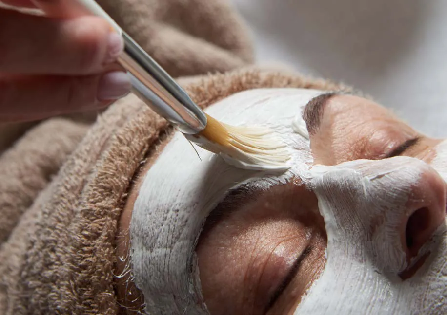 Applicazione di una maschera illuminante sul viso con il pennello